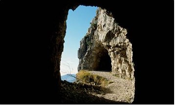 Frotte allegre di turisti sbucano dalla 52^ galleria di questa celeberrima strada, costruita in soli undici mesi, uno dei tanti assurdi miracoli prodotti dalle guerre sulle nostre montagne.Sbucano allegri e sudati, qualcuno un po stravolto, con cani e bambini, e riempiono di vita questa bellissima montagna, cos aperta e luminosa.E difficile pensare che proprio qui, su questa montagna, in una sola tragica giornata di luglio del 1916, caddero pi di 3200 uomini in una inutile battaglia. Poi cambiarono strategia, ma forse non occorreva essere generali per arrivarci, e si misero a scavare buchi. Per tutti i due anni successivi, fino allarmistizio, si combatt sul Pasubio una guerra sotterranea, assurda, estenuante, inutile, che ha lasciato solo resti spettacolari, come questa famosa strada delle 52 gallerie.I crateri lasciati dalle bombe sono dolci depressioni verdi, dove pascolano le pecore e le api ronzano tra i fiori; i gitanti della domenica nemmeno se ne accorgono. La montagna sa guarire le sue ferite, ma le cicatrici restano, profonde, immutabili, malinconiche nella serenit dei luoghi.Tutti questi fiori, il profumo dellerba: sar stato cos anche allora? Chiss se qualche soldatino, suddito di Cecco Beppe o di Sciaboletta, non fa differenza; chiss se nellombra cupa del suo futuro incerto, avr trovato in una stella alpina, nel rododendro in fiore, qualche momento di pace, di speranza.Cantavano gli Alpini: perch se cade  in mezzo ai fiori  non gli importa  di morir Balle, tutte balle, come linfame retorica di regime scolpita nelle lapidi. Quali eroi, in quella guerra fra topi? Rassegnazione, tanta; ma lunico eroismo consisteva nel non perdere la propria dignit di uomini.Siano benvenuti allora tutti gli escursionisti che sbucano allegri alle Porte del Pasubio dalla 52^ galleria, e anche tutti gli altri che salgono dagli Scarubbi e dalla Val Canale.Il vicino rifugio ci accoglie con quintali di polenta e salsicce ed ettolitri di birra e di buon Valpolicella. Riempiamo di vita anche oggi questa bella montagna, che se lo merita. E nascondiamo solo per un attimo lunico vero sentimento che dobbiamo provare per luoghi come questo, per tutte le montagne offese dalle guerre: una grande, immensa, profonda piet.					                Sandro F. 